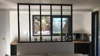 a living room with a window and a microwave at Beau Studio au pied de la Cidatelle in Porto-Vecchio