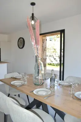 a wooden table with chairs and a vase with flowers at Alivu bergerie Sotta hyper cosy in Sotta