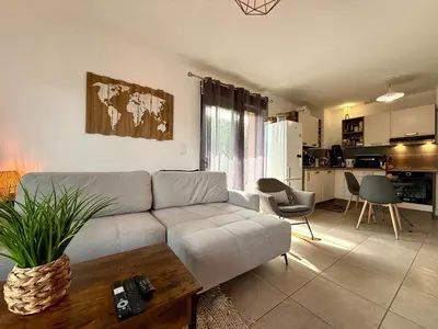 a living room with a couch and a kitchen at PROPRIANO Charmant 2 pièces 46m2 avec Terrasse et balcon in Propriano