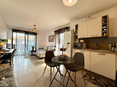 a kitchen and living room with a table and chairs at PROPRIANO Charmant 2 pièces 46m2 avec Terrasse et balcon in Propriano