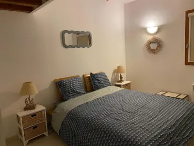 a bedroom with a bed and a mirror on the wall at Maison plage a pied 6 personnes in Albitreccia