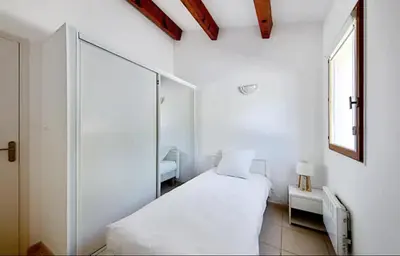 a white room with a bed and a mirror at Maison plage a pied 6 personnes in Albitreccia