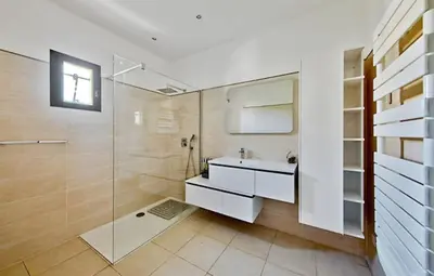 a bathroom with a sink and a glass shower at Maison plage a pied 6 personnes in Albitreccia