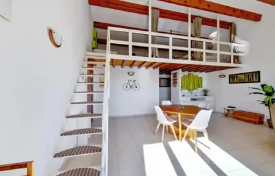 a room with a loft bed and a table and chairs at Maison plage a pied 6 personnes in Albitreccia