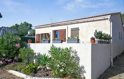 a house with potted plants on the side of it at Maison plage a pied 6 personnes in Albitreccia