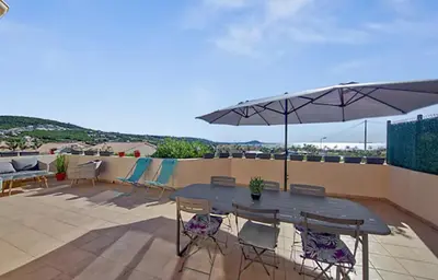 a patio with a table and chairs and an umbrella at Maison plage a pied 6 personnes in Albitreccia