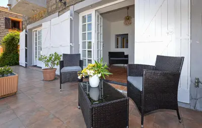 a patio with wicker chairs and a table at Appartement Calanches Piana in Piana