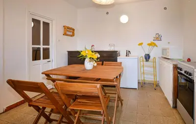a kitchen with a wooden table and chairs in a kitchen at Appartement Calanches Piana in Piana