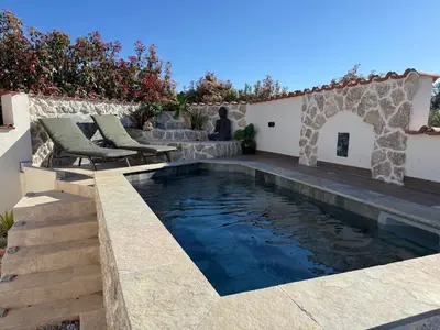 a swimming pool with lounge chairs and umbrellas next to at Villa Anna chambre privée avec salle de bain in Vescovato