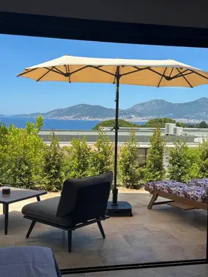 a patio with a table and an umbrella and chairs at Domaine LUMISTELLA 2 in Porticcio
