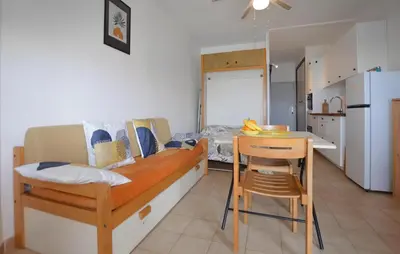 a room with a kitchen and a table and a dining room at Studio Piscine Et Plage in Furiani