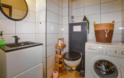 a small bathroom with a washing machine and a sink at Studio Piscine Et Plage in Furiani