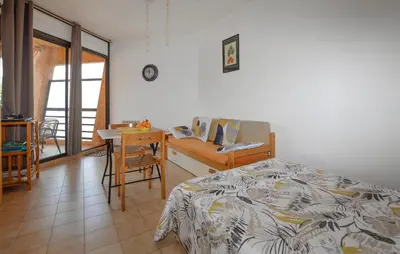 a bedroom with a bed and a desk and a table at Studio Piscine Et Plage in Furiani