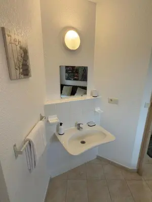 a white bathroom with a sink and a tv at Beautiful accommodation, private residence in Linguizzetta