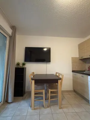 a kitchen with a table with chairs and a tv on the wall at Beautiful accommodation, private residence in Linguizzetta
