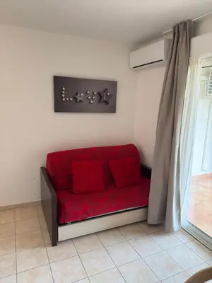 a red couch in a room with a window at Beautiful accommodation, private residence in Linguizzetta