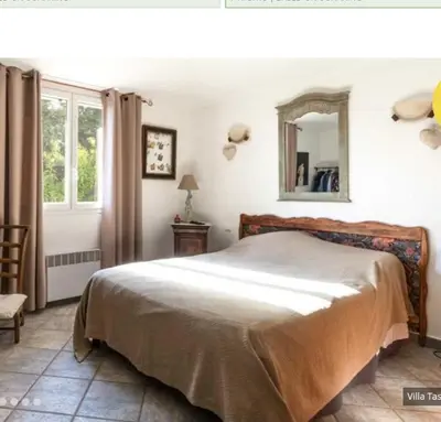 a bedroom with a bed and a mirror on the wall at Villa tasche-vecchio in Porto-Vecchio