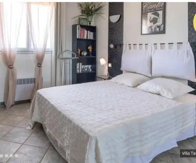 a bedroom with a white bed and a book shelf at Villa tasche-vecchio in Porto-Vecchio