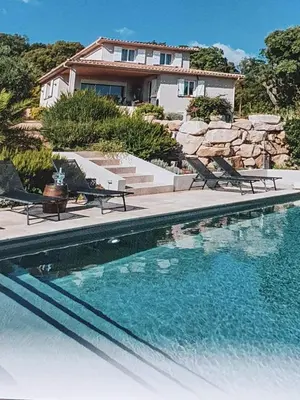 a swimming pool in front of a house at Villa tasche-vecchio in Porto-Vecchio