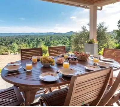a wooden table with food on it on a patio at Villa tasche-vecchio in Porto-Vecchio