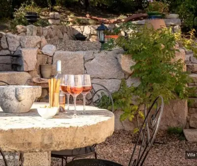 two glasses of wine sitting on a stone table at Villa tasche-vecchio in Porto-Vecchio