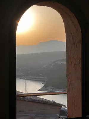 a view of the ocean from a window with the sunset at Tana Torricella in Bonifacio