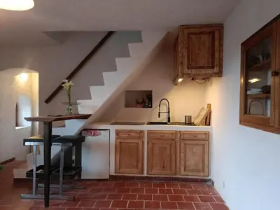 a kitchen with a sink and a staircase at Tana Torricella in Bonifacio