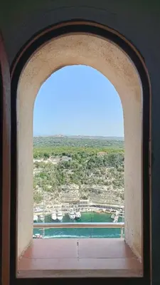 an archway in a building with a view of the water at Tana Torricella in Bonifacio