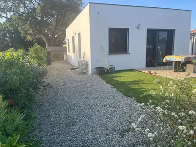 a house with a gravel driveway next to a yard at Maison INDEPENDANTE entre mer et montagne in Prunelli-di-Fiumorbo