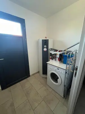 a laundry room with a washing machine and a refrigerator at Maison INDEPENDANTE entre mer et montagne in Prunelli-di-Fiumorbo