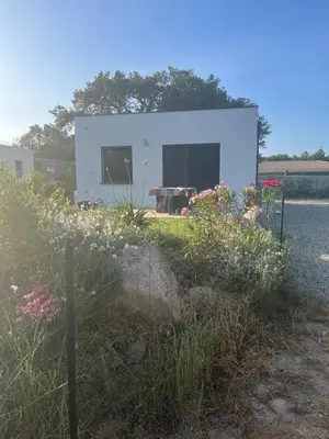 a small white house with flowers in front of it at Maison INDEPENDANTE entre mer et montagne in Prunelli-di-Fiumorbo