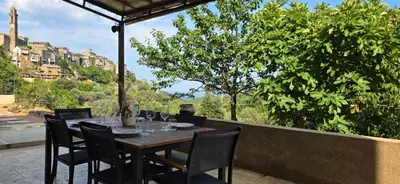 a wooden table and chairs sitting on a patio at La Casuccia in Venzolasca