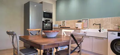 a kitchen with a wooden table and a sink at La Casuccia in Venzolasca