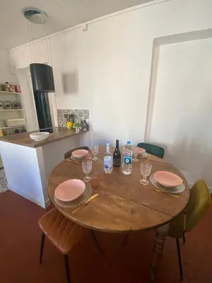 a wooden table with plates and glasses on it in a kitchen at Superbe Appartement au coeur d ajaccio in Ajaccio
