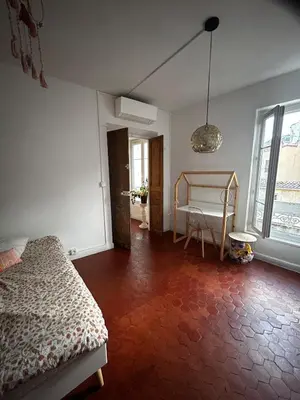 a bedroom with a bed and a table and a window at Superbe Appartement au coeur d ajaccio in Ajaccio