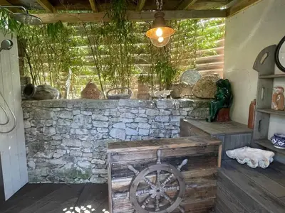 a room with a stone wall and a wooden chest at Villa les pieds dans l'eau in Bonifacio
