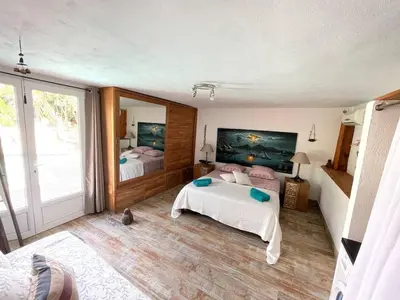 a bedroom with two beds and a large mirror at Villa les pieds dans l'eau in Bonifacio