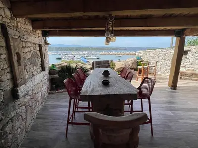 a wooden table and chairs on a patio at Villa les pieds dans l'eau in Bonifacio