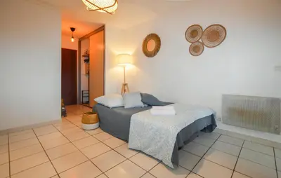 a bedroom with a bed and a table in a room at Gorgeous Apartment In Moriani Plage in Moriani Plage
