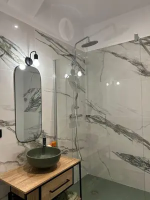 a bathroom with a sink and a mirror at U San Petru -Locations de chambres in Bains de Guitera