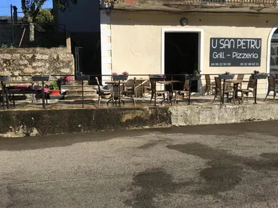a group of tables and chairs outside of a building at U San Petru -Locations de chambres in Bains de Guitera