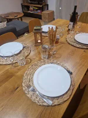 a wooden table with white plates and glasses on it at Agapanthe location in San-Nicolao