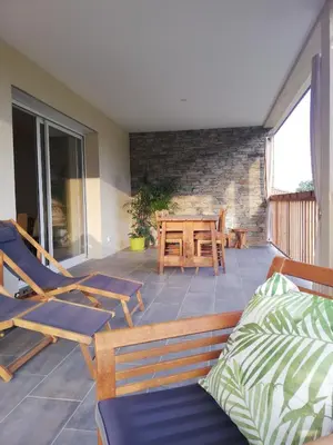 a patio with chairs and a table on a balcony at Agapanthe location in San-Nicolao