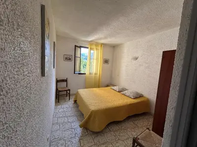 a bedroom with a bed with a yellow blanket at Appartement confortable à Marignana, 50 m² avec 3 chambres in Marignana
