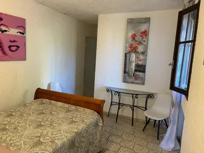 a bedroom with a bed and a table and a window at Appartement confortable à Marignana, 50 m² avec 3 chambres in Marignana