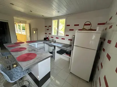 a kitchen with a white refrigerator and red and white tiles at Appartement confortable à Marignana, 50 m² avec 3 chambres in Marignana