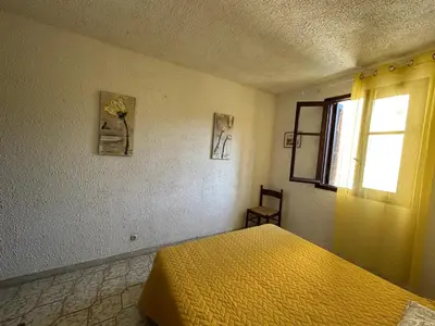a bedroom with a yellow bed and a window at Appartement confortable à Marignana, 50 m² avec 3 chambres in Marignana
