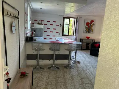 a kitchen with a table and stools in a room at Appartement confortable à Marignana, 50 m² avec 3 chambres in Marignana