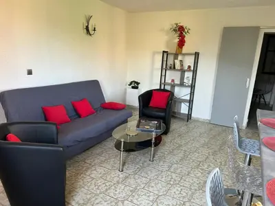 a living room with a blue couch and red pillows at Appartement confortable à Marignana, 50 m² avec 3 chambres in Marignana