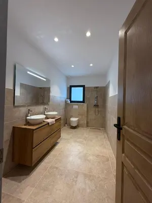a bathroom with two sinks and a toilet and a television at Chez Claudine & Adrien in Figari